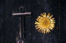Coexistence of traditions: the Christian cross and the Eguzki Lore over the door of a farmhouse