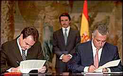 José Luis Rodríguez Zapatero (PSOE) y Javier Arenas (PP) firmando el Pacto de las Libertades y contra el Terrorismo, al fondo José María Aznar, presidente de España en esta época